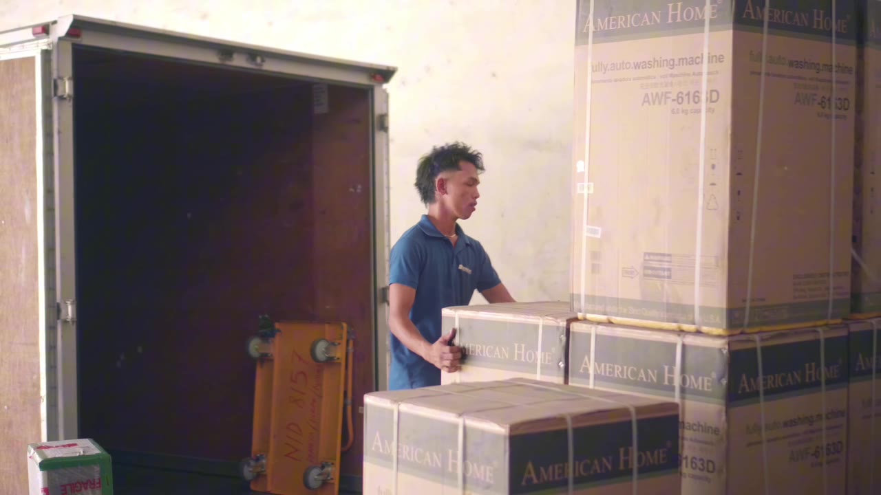 Megatransport helper loading appliance boxes into a truck